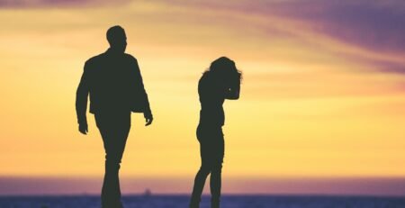 silhouette of man and woman under yellow sky